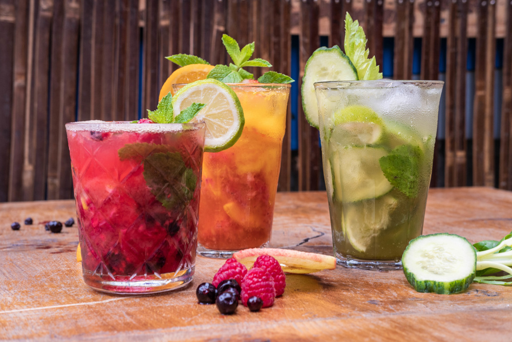 Three glasses of fresh fruit juices in glasses on a wooden table
