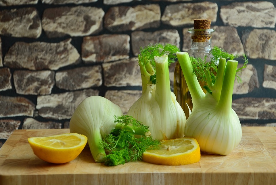 fennel and sliced lemon on a wooden cutting board