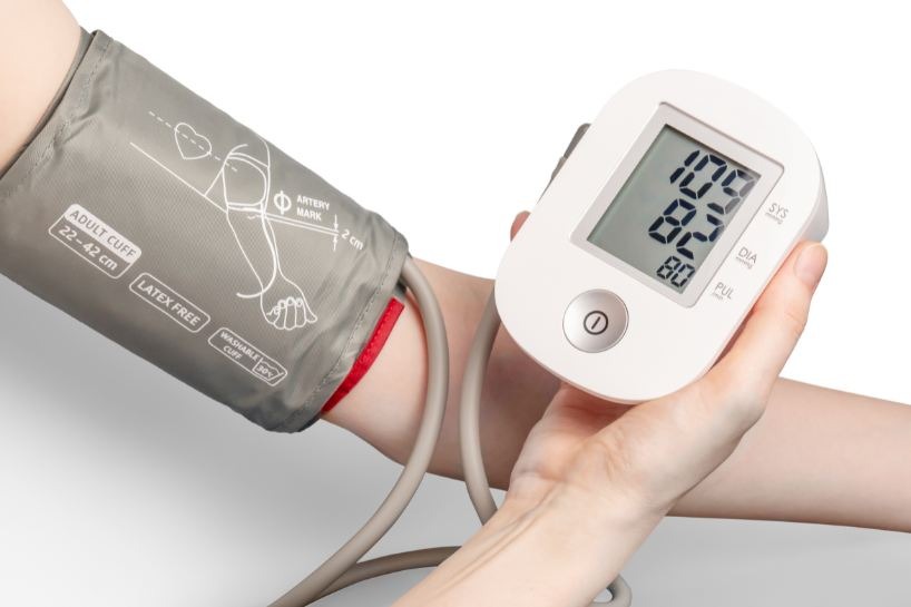 Person using a sphygmomanometer on white background