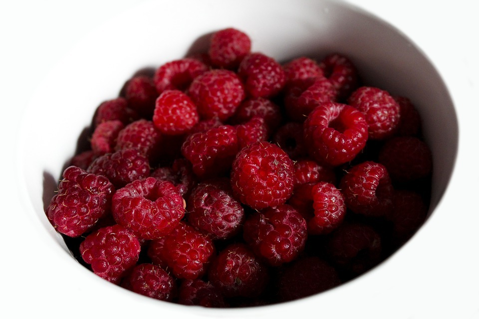 a white bowl of raspberries