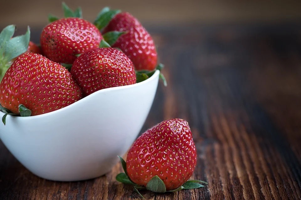 a white bowl of strawberries
